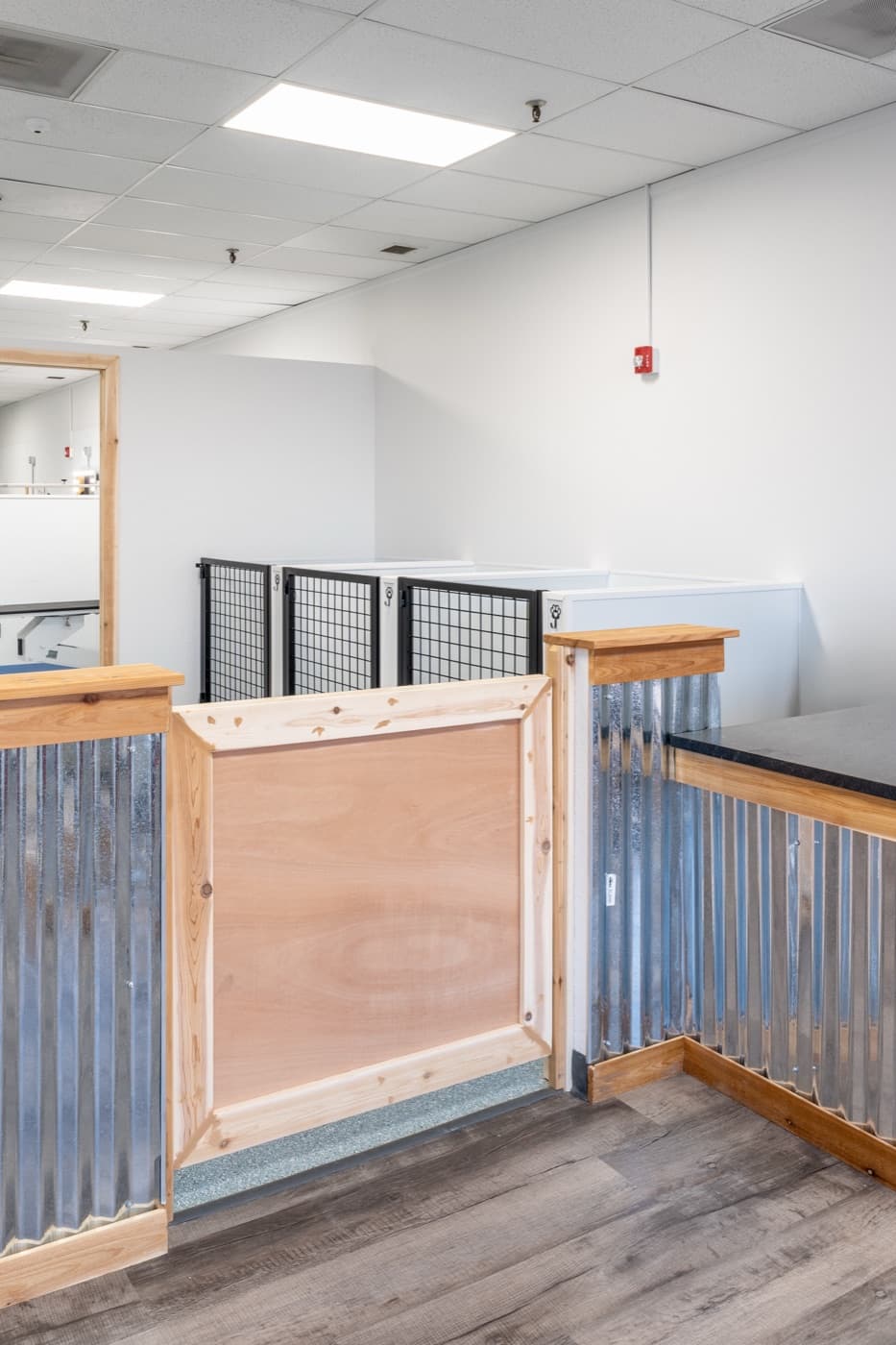 Custom kennel millwork - corrugated metal panels with wood caps and gates