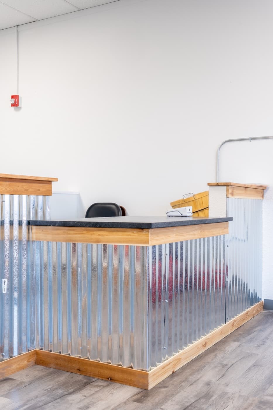Custom reception desk with corrugated metal and stained wood trim at Scruffy's